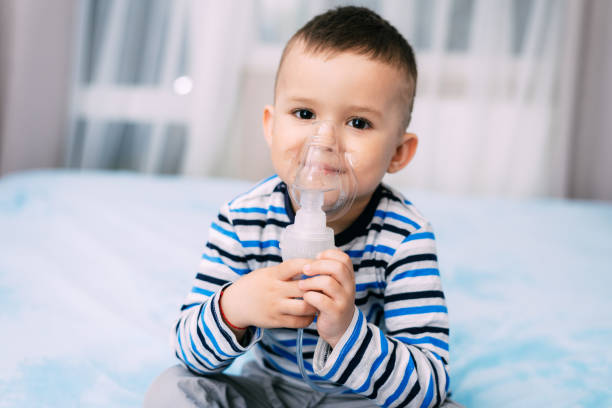 istock Baby boy holding a mask immobilizer sprayer while taking a breath 1145212276