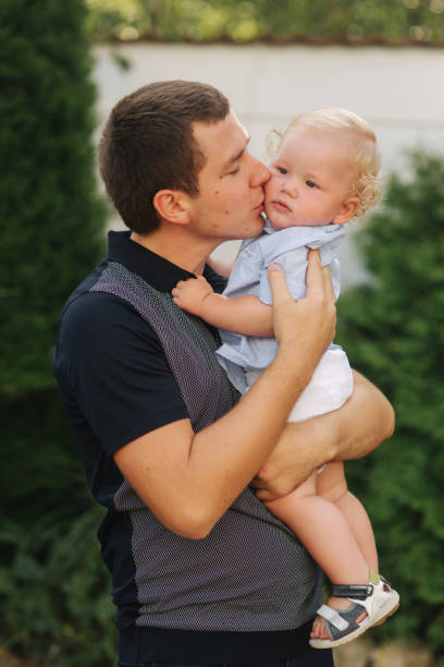 istock Father with sun. Litte boy with dad. Dad holds son in his arms 1145219996