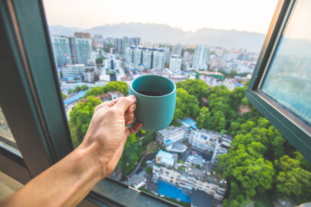 istock Drinking coffee by window in the city 1145223613