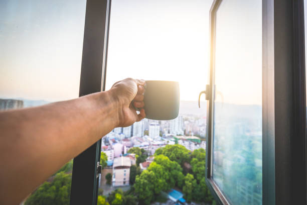 istock Drinking coffee by window in the city 1145223666