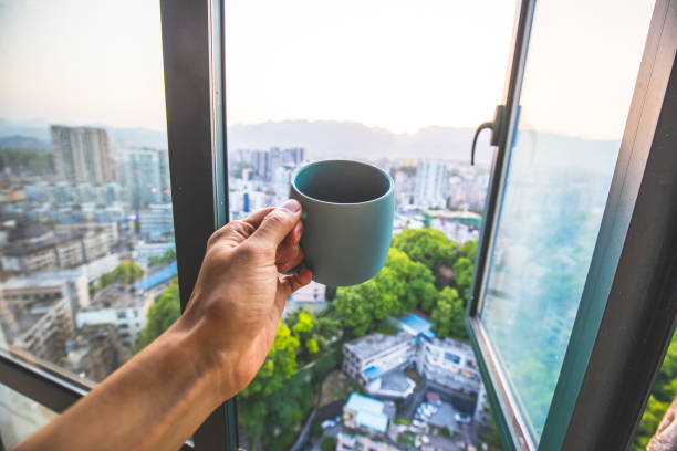 istock Drinking coffee by window in the city 1145223678