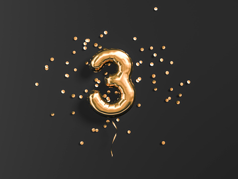 Tres años de cumpleaños. Número 3 globo de papel volador y confeti de oro photo