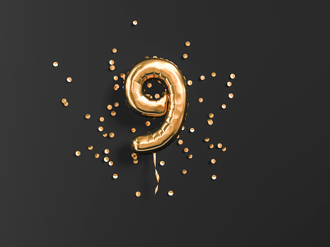Nueve años de cumpleaños. Número 9 globo de papel volador y confeti dorado en negro. Fondo de nueve años de aniversario photo