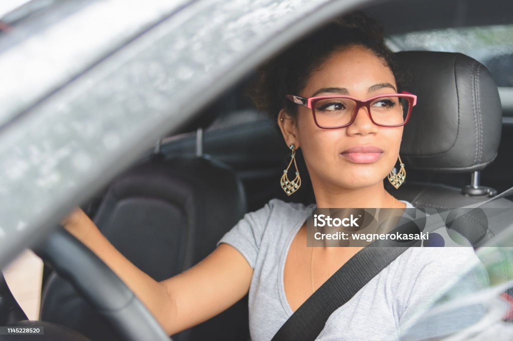 Portrait of young woman driving a car Driving Stock Photo