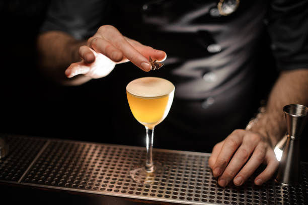 istock Male bartender adding to a cocktail decor of the one anise star 1145229551