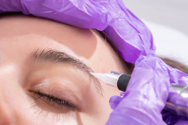 istock Cosmetologist making permanent make up on eyebrows on beautiful girl 1145230042