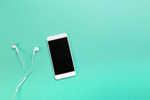 istock smartphone with earphones on blue background text place - Image 1145231773