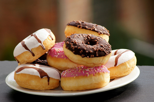 Colorful doughnuts on plates at picnic