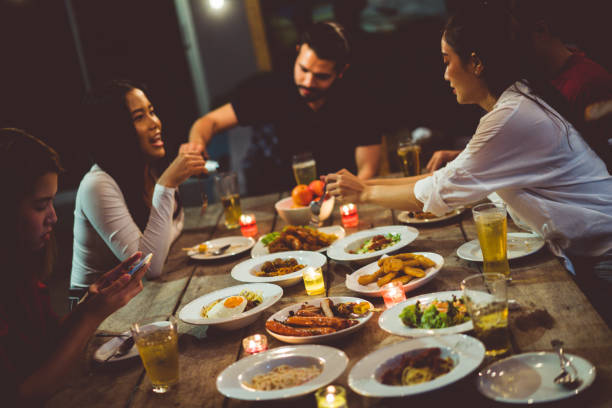 istock Asian group eating and drinking cold beer outside the house at night, having fun talking 1145241165