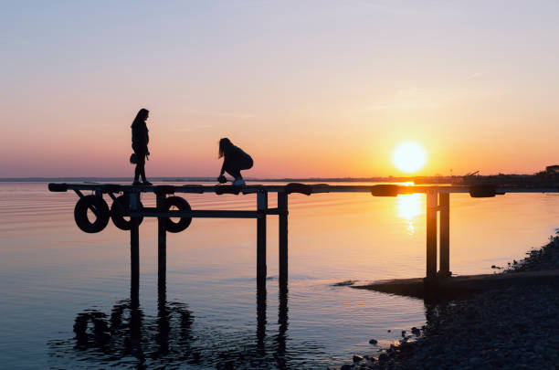 istock figures of people on the bridge at sunset. 1145243352