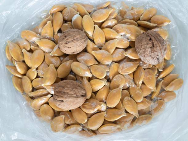 istock Top view on 3 walnuts among pumpkin seeds in shells 1145246028