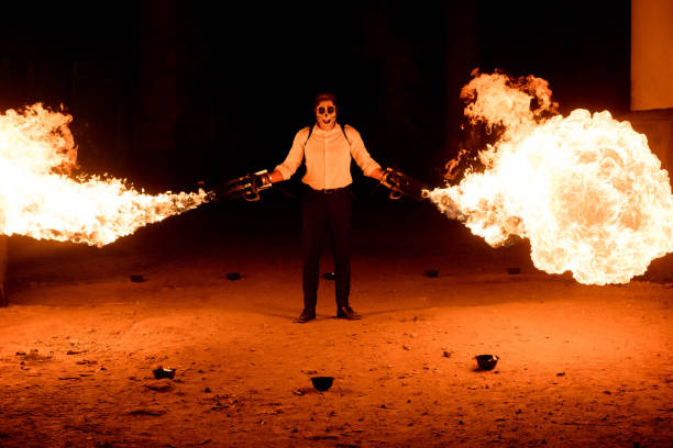istock Halloween man in costume with flamethrower in his hands. Devil makeup on face 1145247086