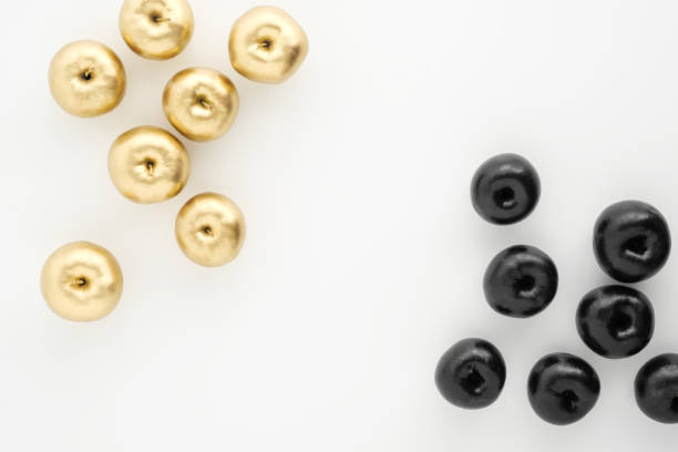 istock Golden and black apples on white background. Two groups, comparison and opposition. 1145248983