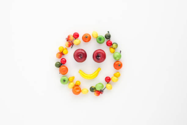 um espalhamento de muitas frutas diferentes pequenas em um fundo branco. sorriso alegre do emoji. - abundance apple red yellow - fotografias e filmes do acervo