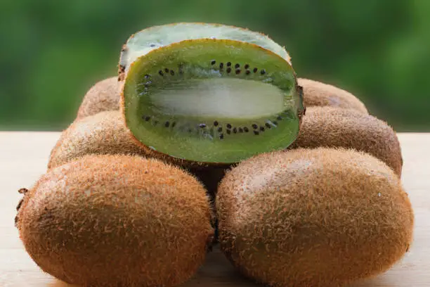 Raw and Sliced Kiwi fruit with green background-image