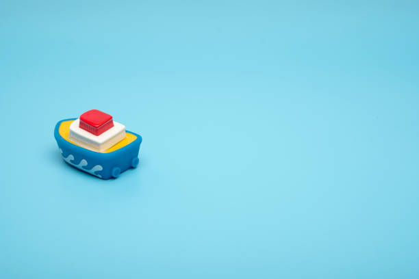 istock Close up little rubber toy boat on a blue background with copy space. 1145249251
