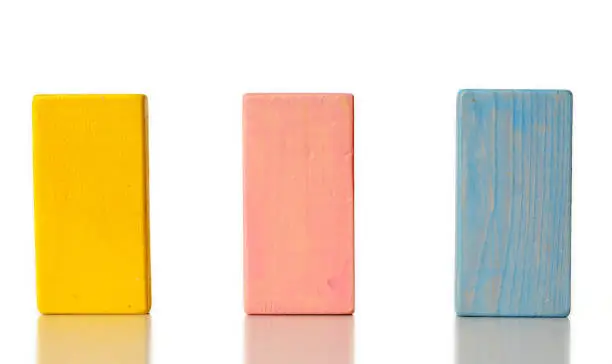 yellow, pink and blue wooden blocks isolated on white background