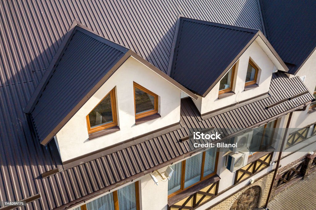 Close-up luchtfoto van het bouwen van zolderkamers exterieur op metalen grind dak, stucwerk muren en plastic ramen. - Royalty-free Dak Stockfoto