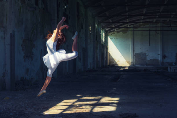 Ballerina dancing in an abandoned building Ballerina dancing in an abandoned building on a sunny summer day. ballerina shadow stock pictures, royalty-free photos & images