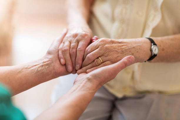istock Nurse consoling her elderly patient by holding her hands 1145255804