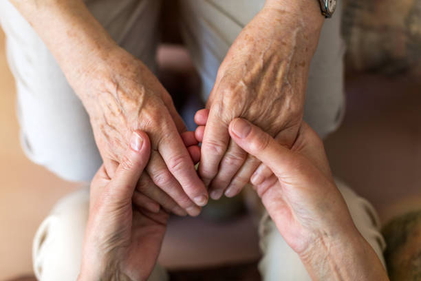 istock Nurse consoling her elderly patient by holding her hands 1145255950
