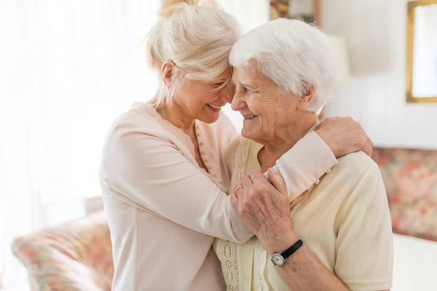 femme aînée passant le temps de qualité avec sa fille - healthcare worker home caregiver senior adult care photos et images de collection
