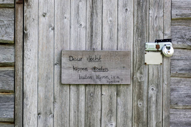 Utrecht, may 2019: A old wooden door is locked with two locks plus a sign saying 