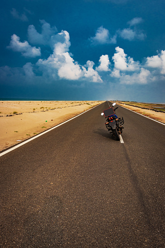 Motorcycle standing on road with left space for you to write something about your experience.