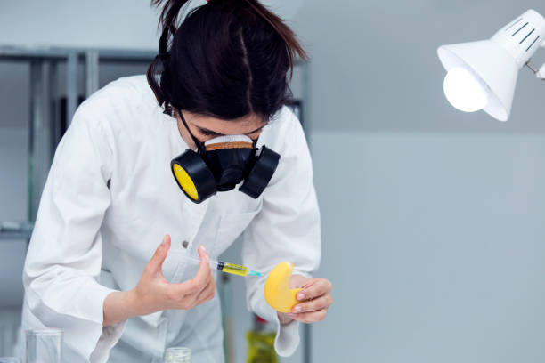매우 독성 화학 물질과 바나나를 주입 하는 여성 의사 - injecting healthy eating laboratory dna 뉴스 사진 이미지