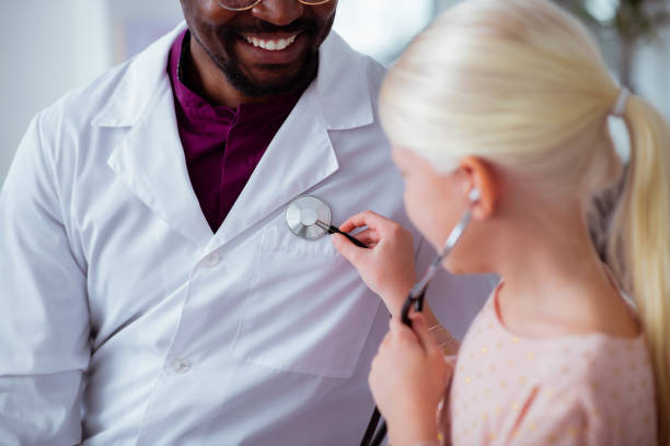 istock Blonde patient using stethoscope playing with doctor 1145261554