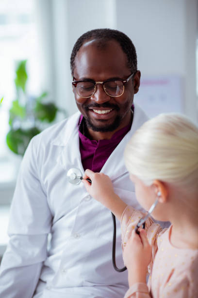 istock Dark-skinned pediatrician feeling happy spending day with daughter 1145261559