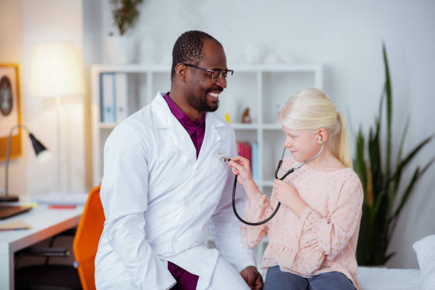 istock Cheerful pediatrician feeling good communicating with girl 1145261561