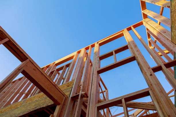 istock Looking up new construction beams under a clear blue sky with sunlight 1145266432