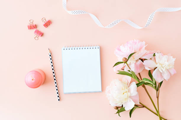 istock Mockup white notebook with light pink peonies on a pink background 1145267949