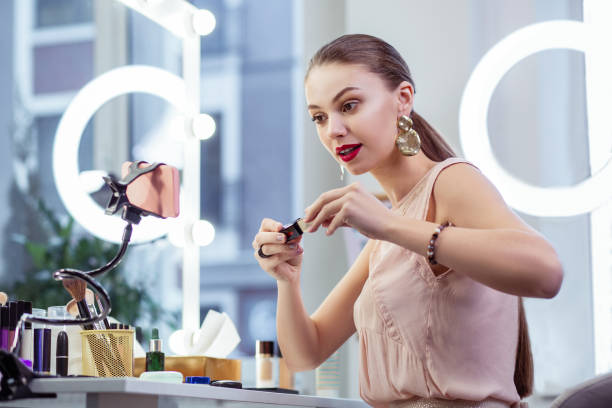istock Pretty young woman testing cosmetics on camera 1145268687