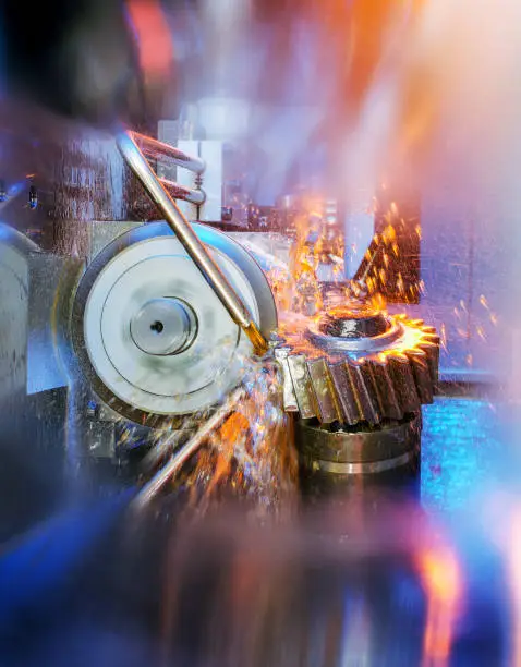 gear wheel, being processed by a grinding machine with coolant