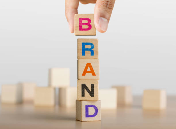 Hand arranging wooden blocks with the word BRAND. Brand building concept. stock photo