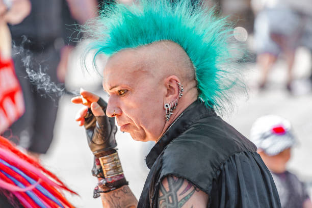 Expressive punk metalhead with a haircut Iroquois at the Annual Leipzig festival Leipzig, Germany - May 21, 2018: Expressive punk metalhead with a haircut Iroquois at the Annual Leipzig festival emo hair guys stock pictures, royalty-free photos & images