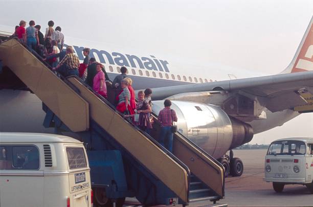 Dusseldorf, North Rhine Westphalia, Germany, 1976. Boarding at the Dusseldorf airport. Passengers board a Germanair aircraft via a gangway.