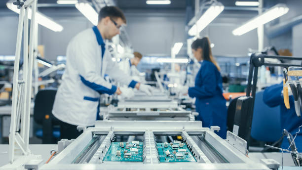 istock Shot of an Electronics Factory Workers Assembling Circuit Boards by Hand While it Stands on the Assembly Line. High Tech Factory Facility. 1145276220