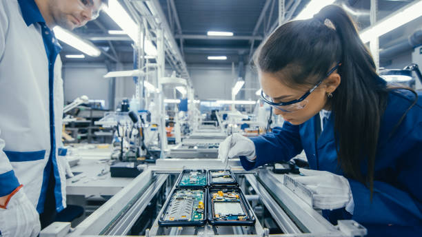 istock Shot of an Electronics Factory Workers Assembling Circuit Boards by Hand While it Stands on the Assembly Line. High Tech Factory Facility. 1145276221