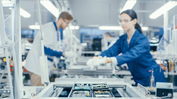 istock Shot of an Electronics Factory Workers Assembling Circuit Boards by Hand While it Stands on the Assembly Line. High Tech Factory Facility. 1145276228