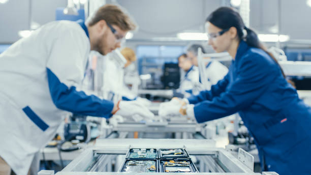 istock Shot of an Electronics Factory Workers Assembling Circuit Boards by Hand While it Stands on the Assembly Line. High Tech Factory Facility. 1145276232