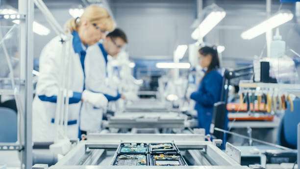 istock Shot of an Electronics Factory Workers Assembling Circuit Boards by Hand While it Moves on the Assembly Line. High Tech Factory Facility. 1145276239