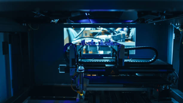 Automated Robotic Industrial Equipment is Testing Electronic Printed Circuit Board with Blue Neon Light and Laser Technology After Assembly.