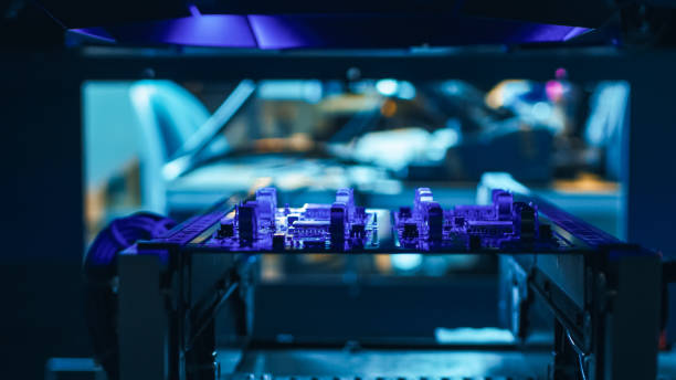 istock Automated Robotic Industrial Equipment is Testing Electronic Printed Circuit Board with Purpule Neon Light and Laser Technology After Assembly. 1145276363