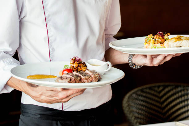 istock the waiter serves meat and fish dishes 1145276370