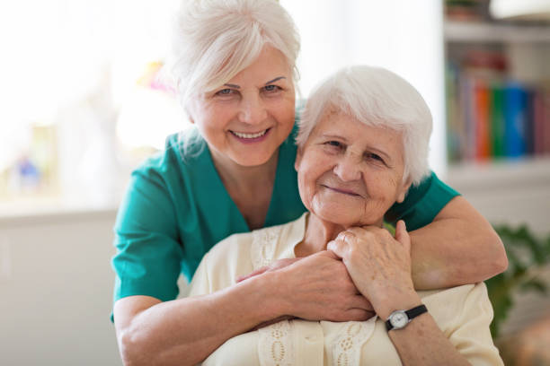 home caregiver and senior adult woman - senior adult hospital uniform gray hair imagens e fotografias de stock