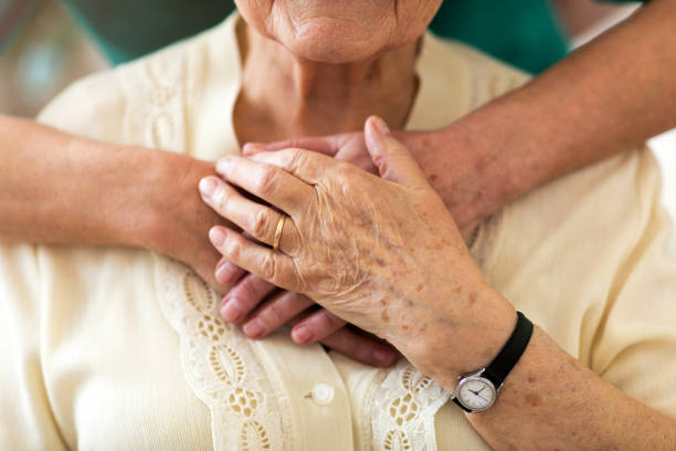 istock Nurse consoling her elderly patient by holding her hands 1145276591