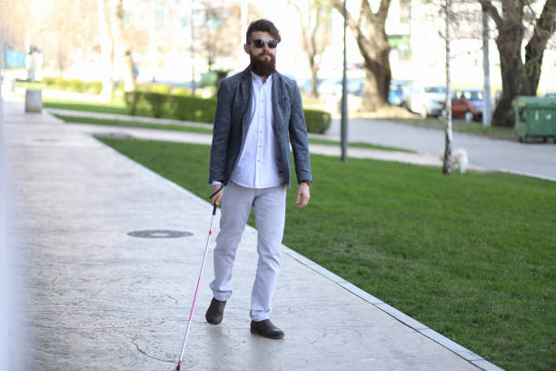 istock Blind and bearded man with a walking stick on the street 1145281080